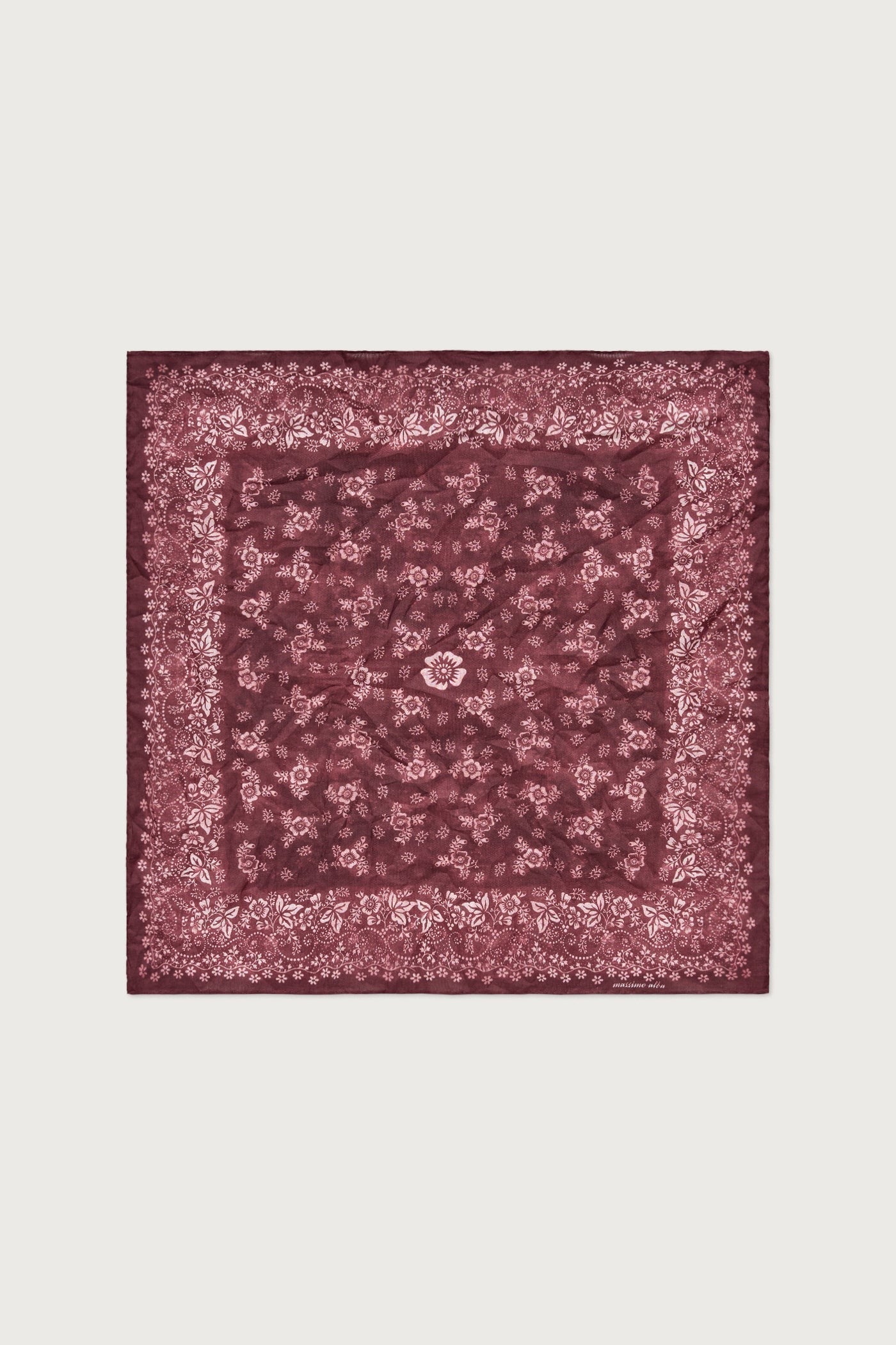 Burgundy patterned square scarf on a light beige background